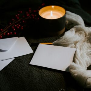 Cards and envelopes on a candlelit wooden table